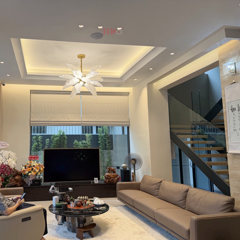 Loa âm trần trong phòng khách với sofa và cầu thang