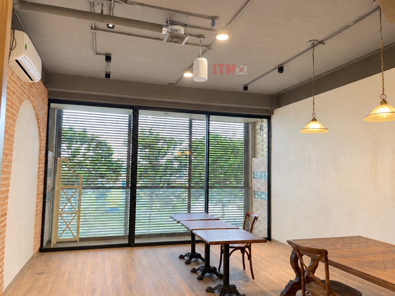 Loa thả trần ở trên khu bàn ghế sát cửa kính trong quán cà phê