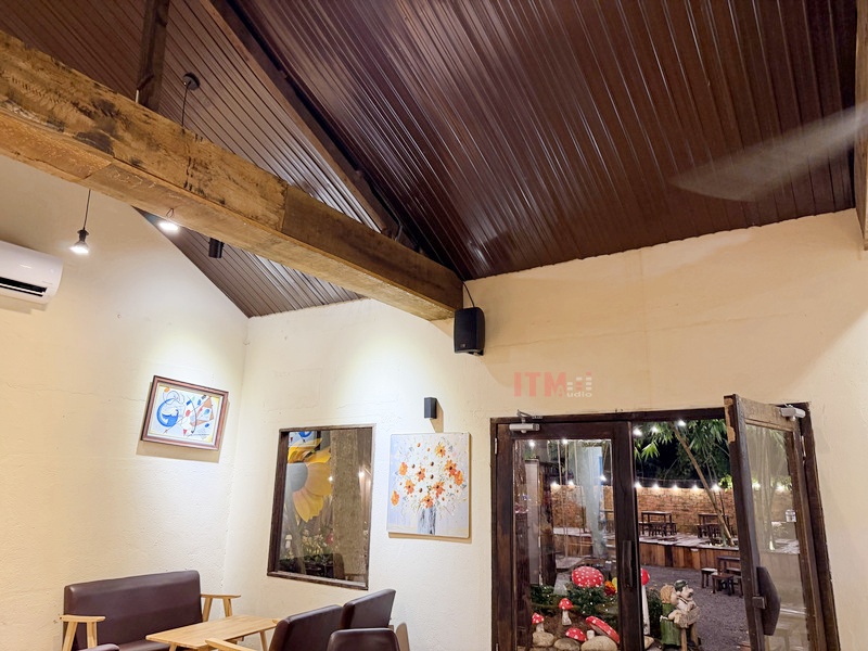 Loa treo tường phía trên khu bàn ghế trong quán