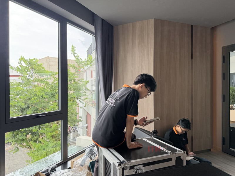 Kỹ thuật viên T&C Sài Gòn Audio làm việc với hệ thống tại dự án Hóc Môn, ảnh minh họa việc kiểm tra thiết bị, không phải ảnh đo âm học.