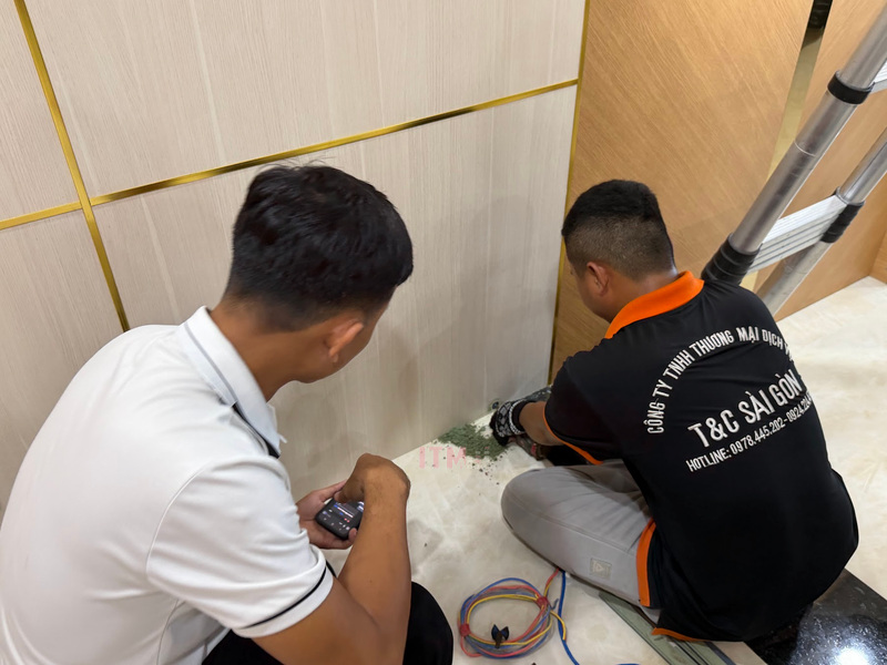 Kỹ thuật viên T&C thi công đường dẫn dây tại chân vách