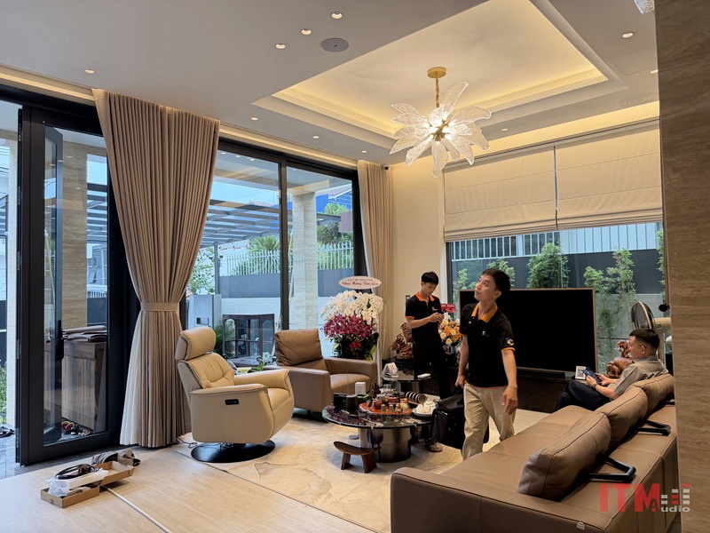 Loa âm trần trong phòng khách với trần giật cấp, đèn và rèm